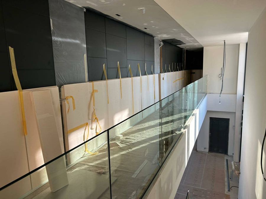 Barandilla de vidrio recién instalada, con la cinta de protección todavía puesta