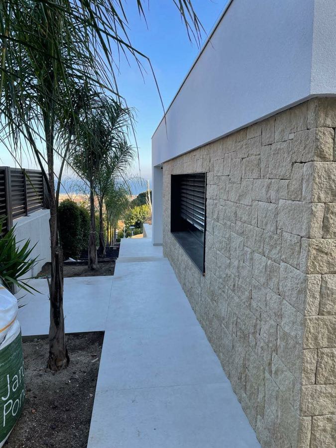 Fachada acabada con revestimiento de piedra natural en una vivienda del Maresme