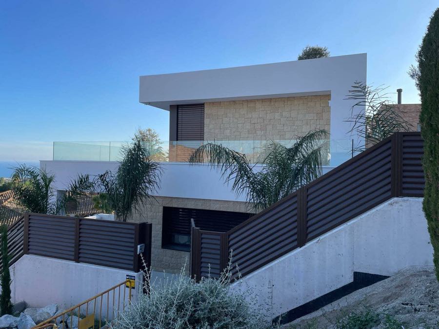 Vivienda unifamiliar de obra nueva con fachada combinada de piedra natural y revestimiento blanco